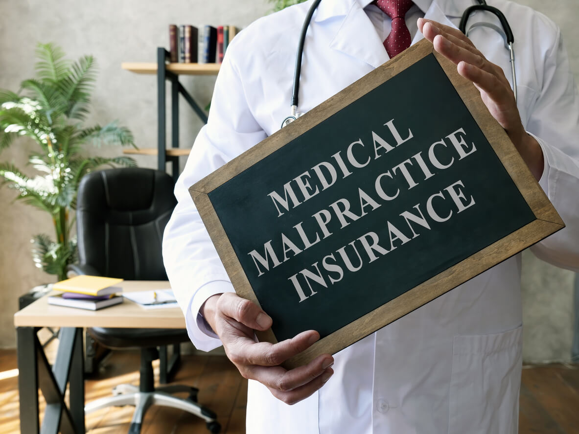 Doctor with blackboard that says medical malpractice insurance