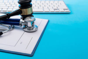 Gavel and stethoscope on blue background.