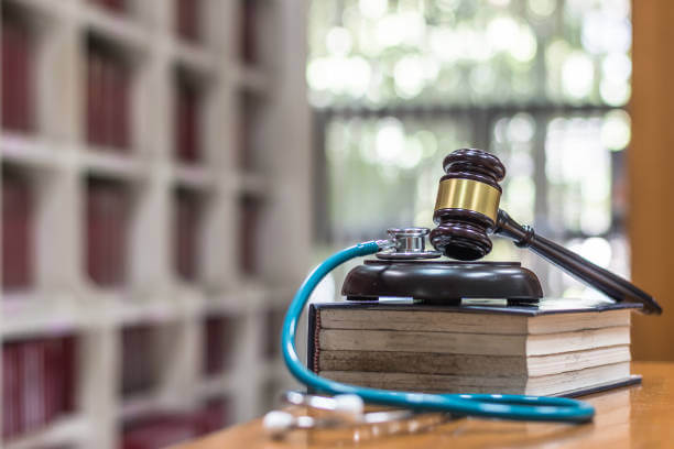 Forensic medicine investigation or malpractice justice concept with judge gavel and medical stethoscope on law textbook in library archive study room