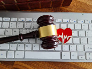 Hammer stethoscope heart cardiology keyboard and medical law concept. Medical online consultation and fraud crimes