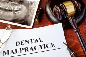 Dental Malpractice form, and gavel on a surface.