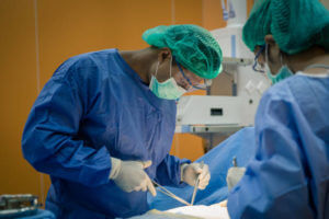 Doctor And Nurse Suture Patient In Emergency Room