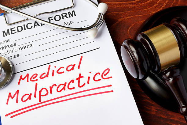 Medical form with words Medical Malpractice and gavel.