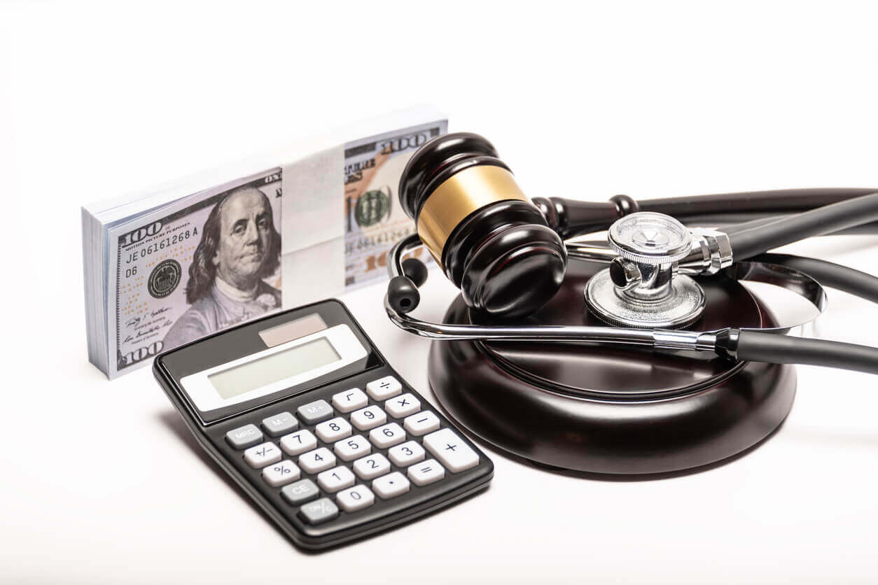 A conceptual image featuring a gavel, cash, and stethoscope symbolizing medical malpractice litigation