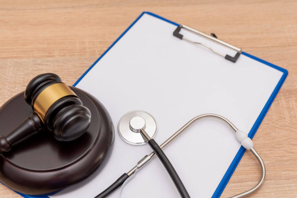 Medical Malpractice Insurance Coverage concept with stethoscope and gavel on clipboard.